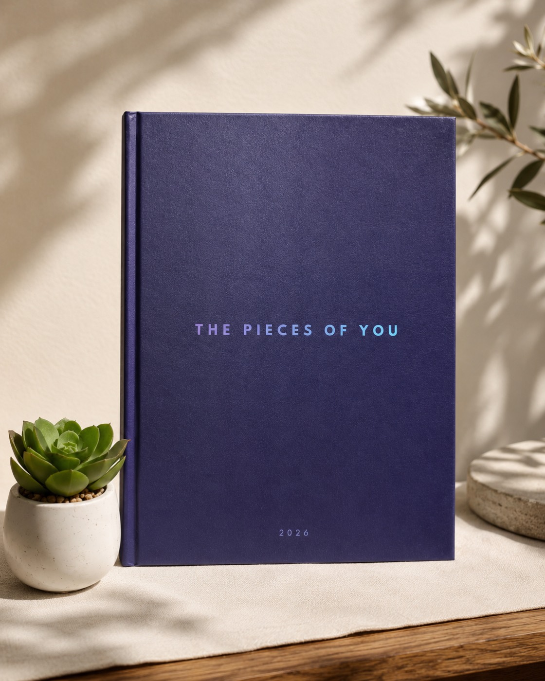 Navy hardbound photobook titled The Pieces Of You, 2026