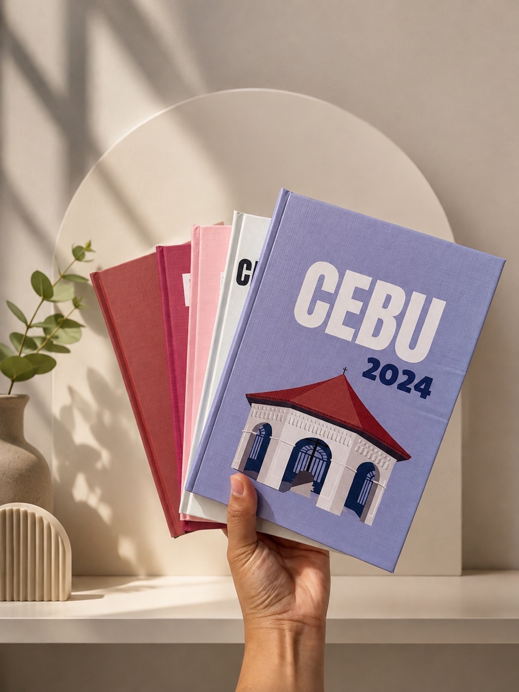 A lineup of five colorful Paper Collective hardbound photobooks standing side by side